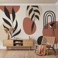 Rattan koltuk ve ahşap konsol arkasında terracotta ile siyah soyut botanik yaprak desenli boho salon duvar kağıdı
